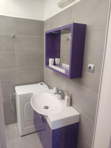 a bathroom with a white sink and a purple cabinet at Angel House in Ermoupoli