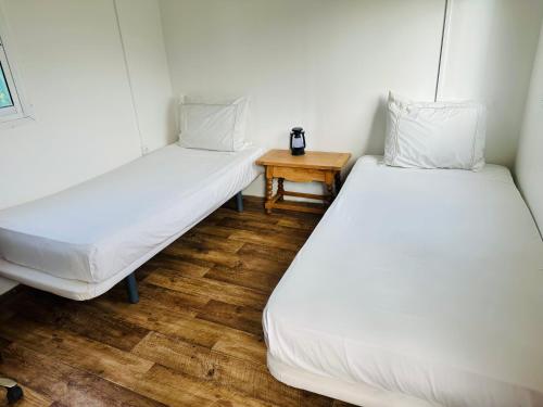 two beds in a room with a small table at Bungalow with Pool View & Breakfast in Marrakesh