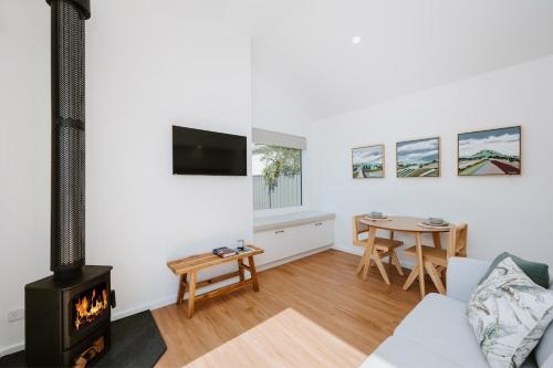 a living room with a fireplace and a table at The Hideaway on McFarlane, Mudgee in Mudgee