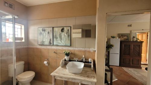 a bathroom with a toilet and a sink at AtHome Apartments in Mokopane