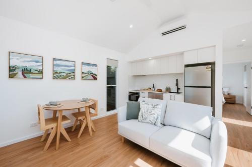 a living room with a white couch and a table at The Hideaway on McFarlane, Mudgee in Mudgee