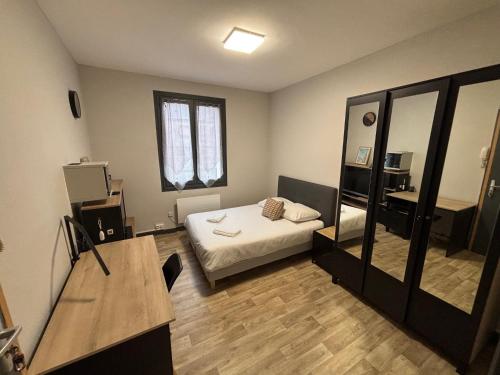 a bedroom with a bed and a desk and a mirror at Sur Tulle - Le Refuge - 1 Piece in Tulle