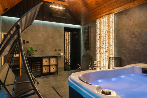 a bathroom with a tub and a table and chairs at LakeHome&Spa nad Jeziorem Czorsztyńskim in Kluszkowce