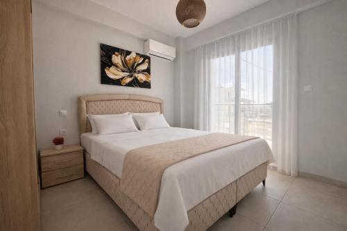 a bedroom with a large bed and a large window at Ariadne Stay Complex by Horizon Homes in Ofrínion