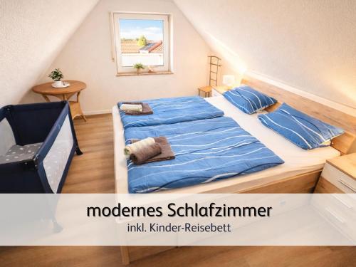 a bedroom with a bed with blue sheets and a window at strandnah & ruhig für 4 Pers in Bensersiel