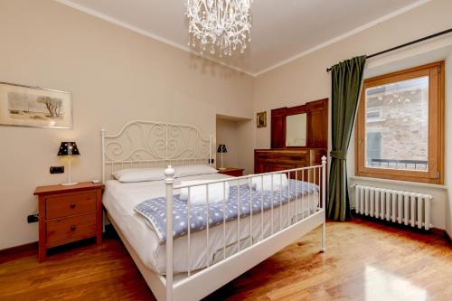 a bedroom with a white bed and a chandelier at Central Square in Sirmione