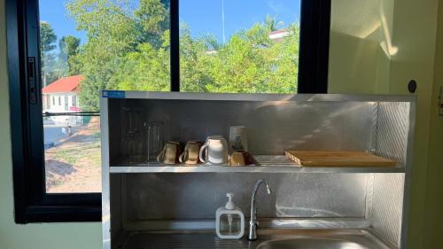a kitchen counter with a sink and a window at Chill House in Ko Phangan
