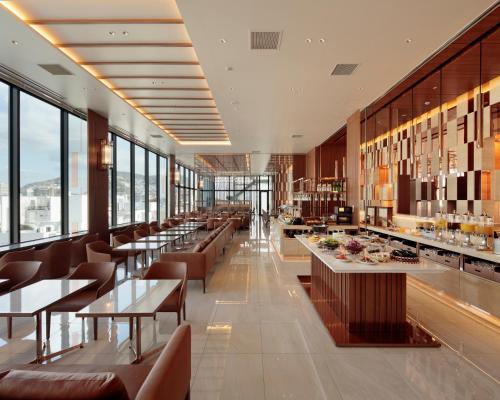 a restaurant with tables and chairs and windows at Candeo Hotels Nagasaki Shinchi Chinatown in Nagasaki