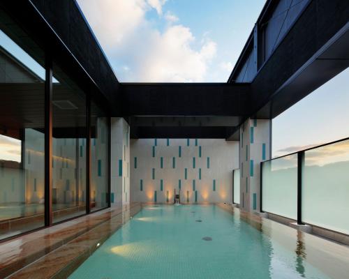 an indoor swimming pool in a building with large windows at Candeo Hotels Nagasaki Shinchi Chinatown in Nagasaki