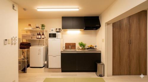 a kitchen with a refrigerator and a microwave at Newly Renovated 2025 秋リフォーム済 RC205 in Tokyo