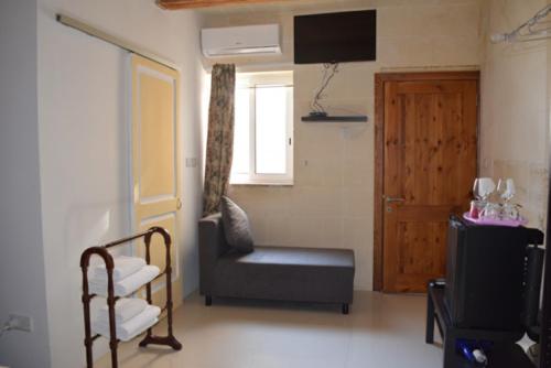 a living room with a chair and a television at St George of Lydda B&B in Victoria