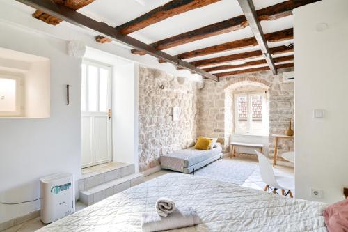 a bedroom with a large bed and a stone wall at Best view! Rooftop with Garden - Old Town Nr404 in Kotor