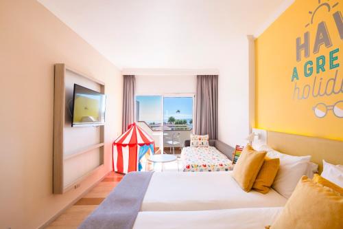 a hotel room with a bed and a childs tent at Abora Continental by Lopesan Hotels in Playa del Ingles