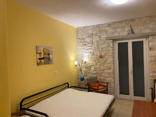 a bedroom with a bed and a stone wall at Villa Effie in Aspro Chorio Paros