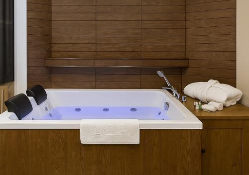 a bath tub in a bathroom with a sink at ERSA Hotel in Tuzla