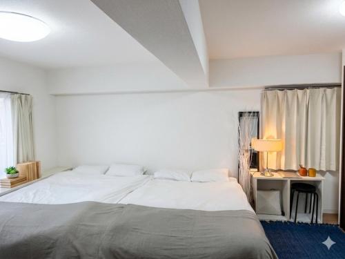 a bedroom with a large white bed with a blue rug at Newly Renovated 2025 秋リフォーム済 RC206 in Tokyo