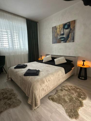 a bedroom with a large bed with two towels on it at DIAMOND MIRAGE Militari Residence in Chiajna