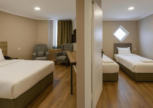 a hotel room with two beds and a desk at ERSA Hotel in Tuzla