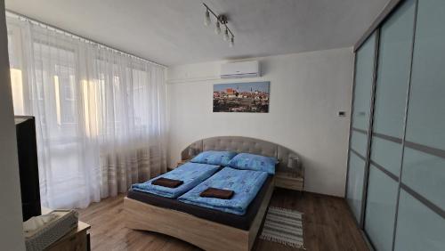 a bedroom with a bed with blue sheets in it at Apartmán Hálkova in Znojmo