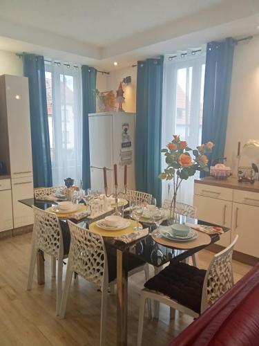 a dining room with a table with chairs and a refrigerator at Glamorous flat in Mertzwiller in Mertzwiller