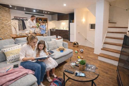 a woman and a little girl sitting on a couch in a living room at Ikebukuro area, Close to Shinjuku, three layer house, Viewing terrace, 6 min walk to subway stn, 近池袋新宿 全新三层别墅有露台 地铁站步行6分 直达新宿 东京塔 哈利波特主题乐园 公交站步行3分 最大7人 in Tokyo