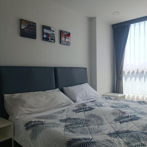 a bedroom with a bed with a blue and white comforter at Therizinpattaya in Pattaya South