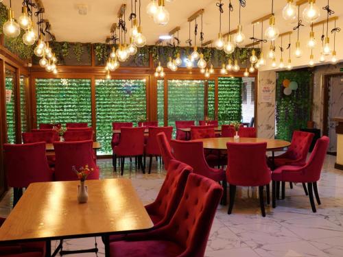 a restaurant with wooden tables and red chairs at Stay Inn Express, Cambridge in Cambridge