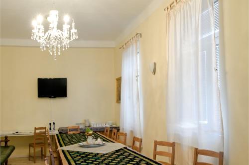 a dining room with a table and a chandelier at Hostel Sonce in Ptuj