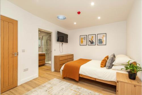 a bedroom with a large bed and a bathroom at 6 En-Suites with 7 Beds Near Arena & City in Nottingham