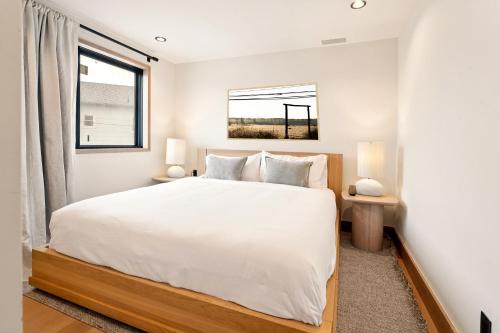 a bedroom with a white bed and a window at Offshore Spa & Residences in Montauk