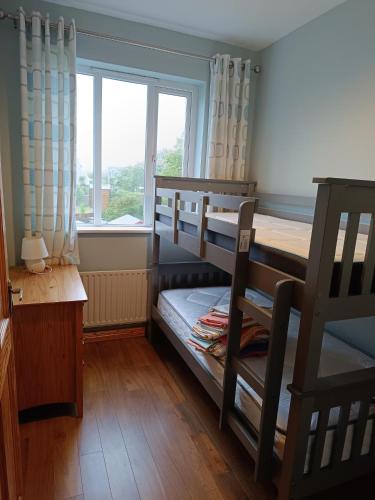 a bedroom with two bunk beds and a window at 4 Bed Close to Beach and Village in Enniscrone