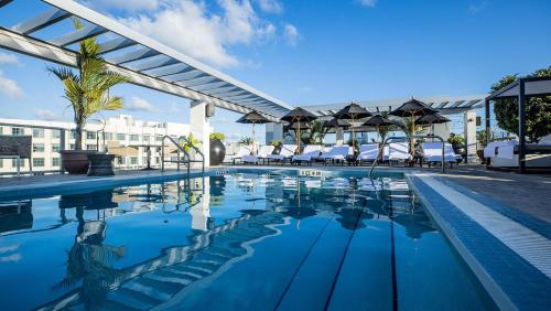 a pool at a hotel with chairs and umbrellas at Angler's Hotel - Miami Beach in Miami Beach