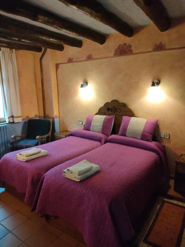 a bedroom with a large bed with purple blankets at Casa Rural El Ensueño in Caneto