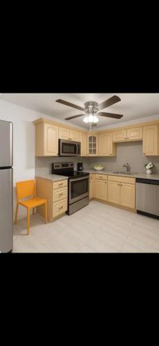 a kitchen with wooden cabinets and a ceiling fan at Omaha Wynwood in Miami