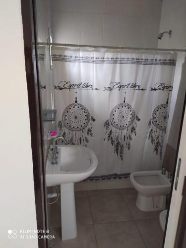 a bathroom with a sink and a shower curtain at Complejo EyE in General Roca