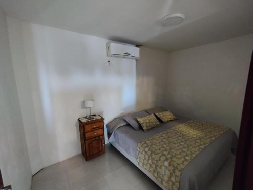 a small bedroom with a bed and a night stand at Complejo EyE in General Roca