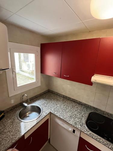 a small kitchen with a sink and red cabinets at Close to the beach duplex in Tossa de Mar
