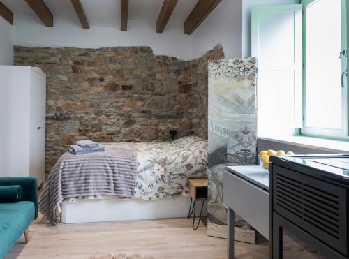 a bedroom with a bed and a brick wall at El Sueño, Pilaro in Barres