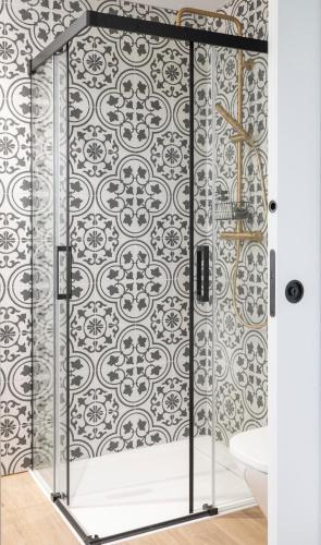 a shower with a black and white patterned wall at El Sueño, Pilaro in Barres