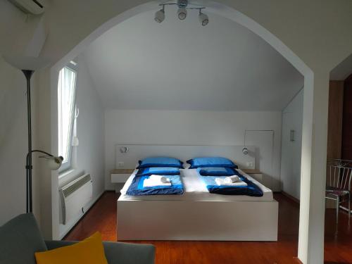 ein Schlafzimmer mit einem Bett mit blauen Kissen in der Unterkunft Teos Apartments in Mostar