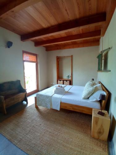 a bedroom with a large bed and a couch at Una casa tra gli alberi in Tresivio
