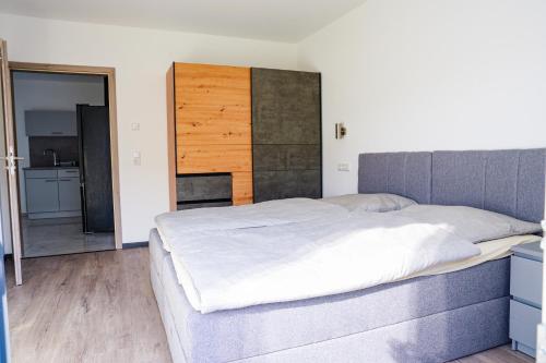 a bedroom with a large bed with a wooden headboard at La Casa Motel in Schaafheim