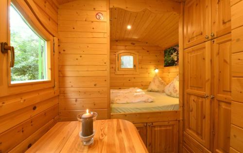 a log cabin bedroom with a bed in it at NATURAMA Brombachsee Schäferwagenhotel in Pleinfeld