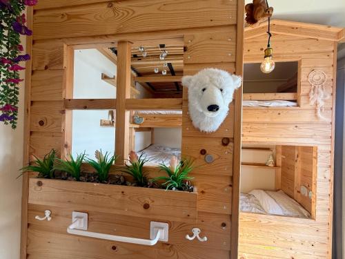 a teddy bear in a wooden room with plants at NEW - Private Residence with Sauna - on a lake near Amsterdam in Vinkeveen