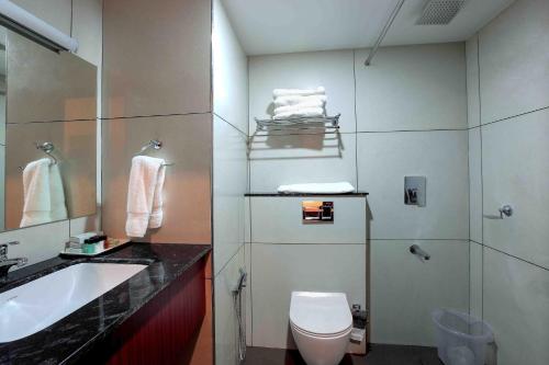 a bathroom with a toilet and a sink and a shower at Hotel Indraprastha Karunagapally in Panmana