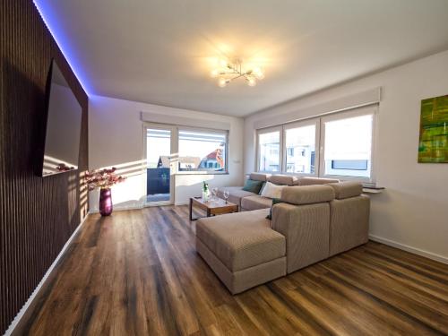 a living room with a couch and a tv at Hermes Apartments Siebengebirge in Königswinter
