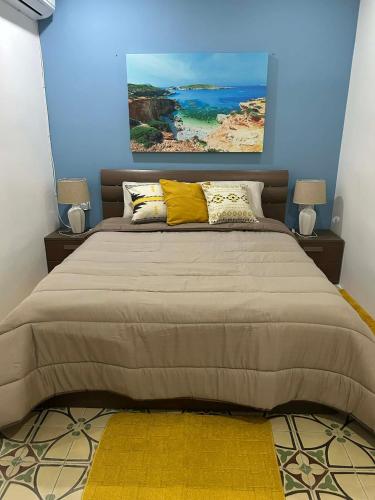 a bedroom with a large bed with yellow pillows at Coral Reef Charming studio by the three old cities in Cospicua