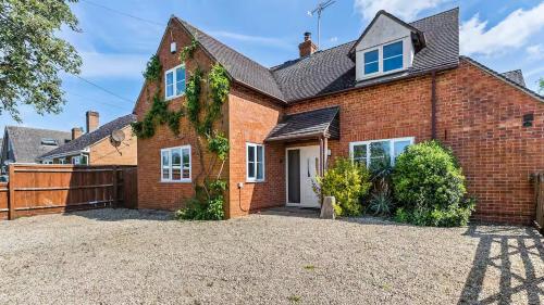 a brick house with a large driveway at Northbrook in Tackley