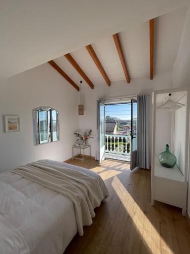 a bedroom with a large bed and a balcony at Bahía de Pedreña in Pedreña
