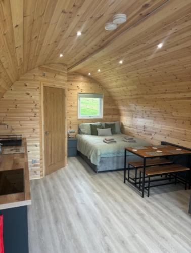 a bedroom with a bed in a wooden cabin at Caerlaverock Glamping - Sycamore in Dumfries